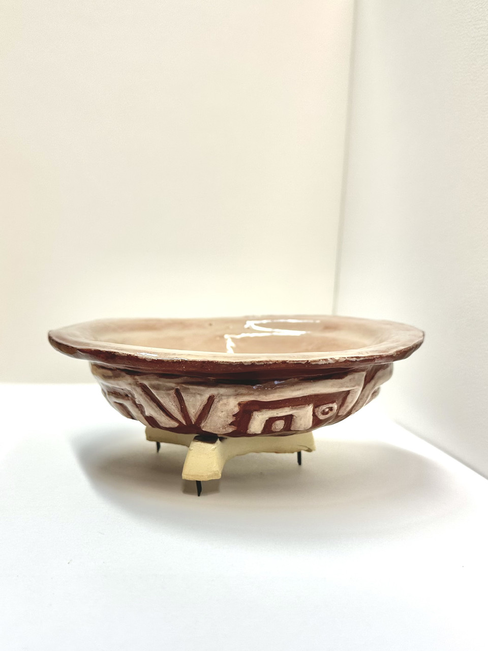 A three legged bowl with a shallow lip.