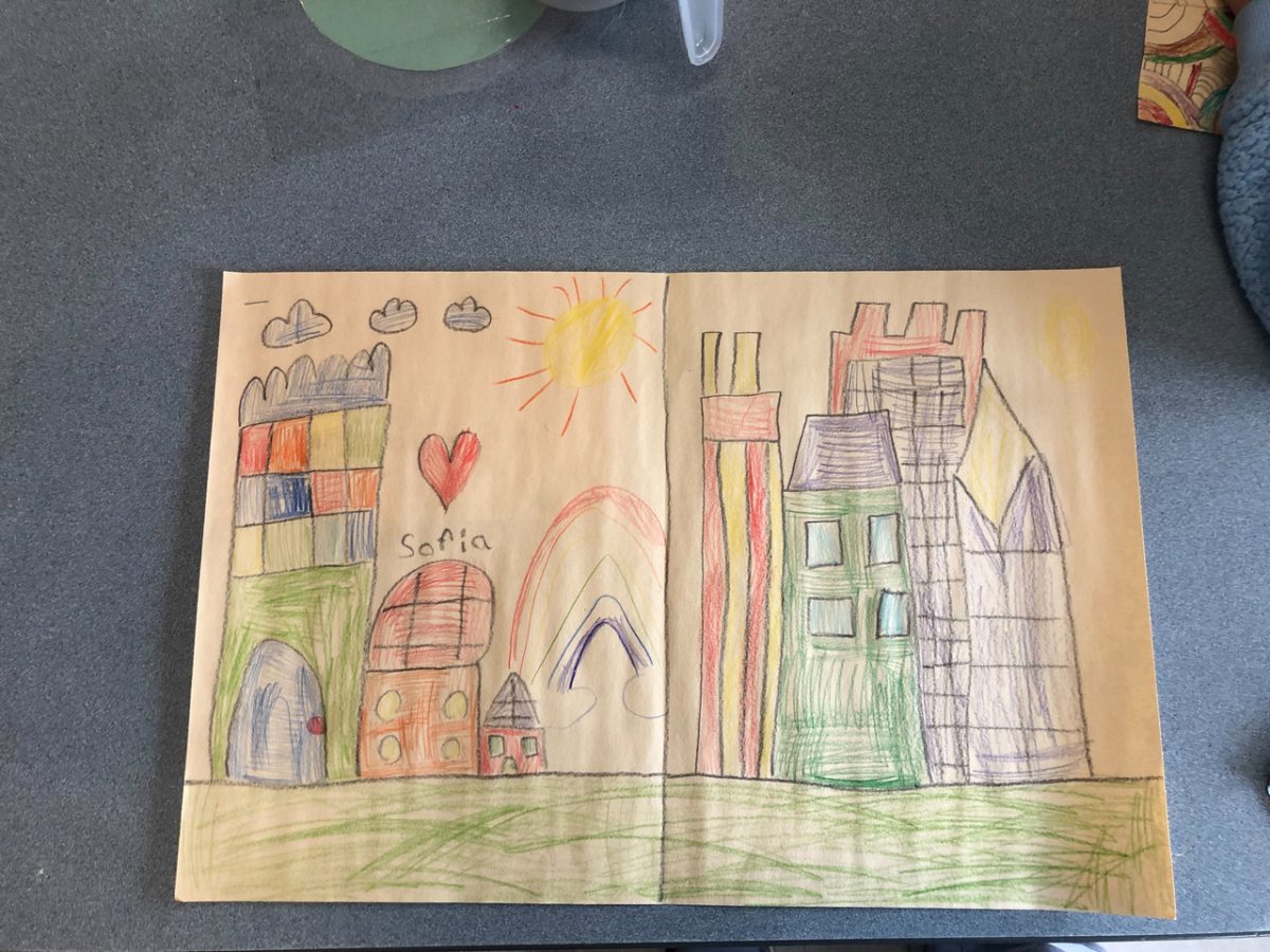 Cityscape of many buildings with a rainbow in the center.
