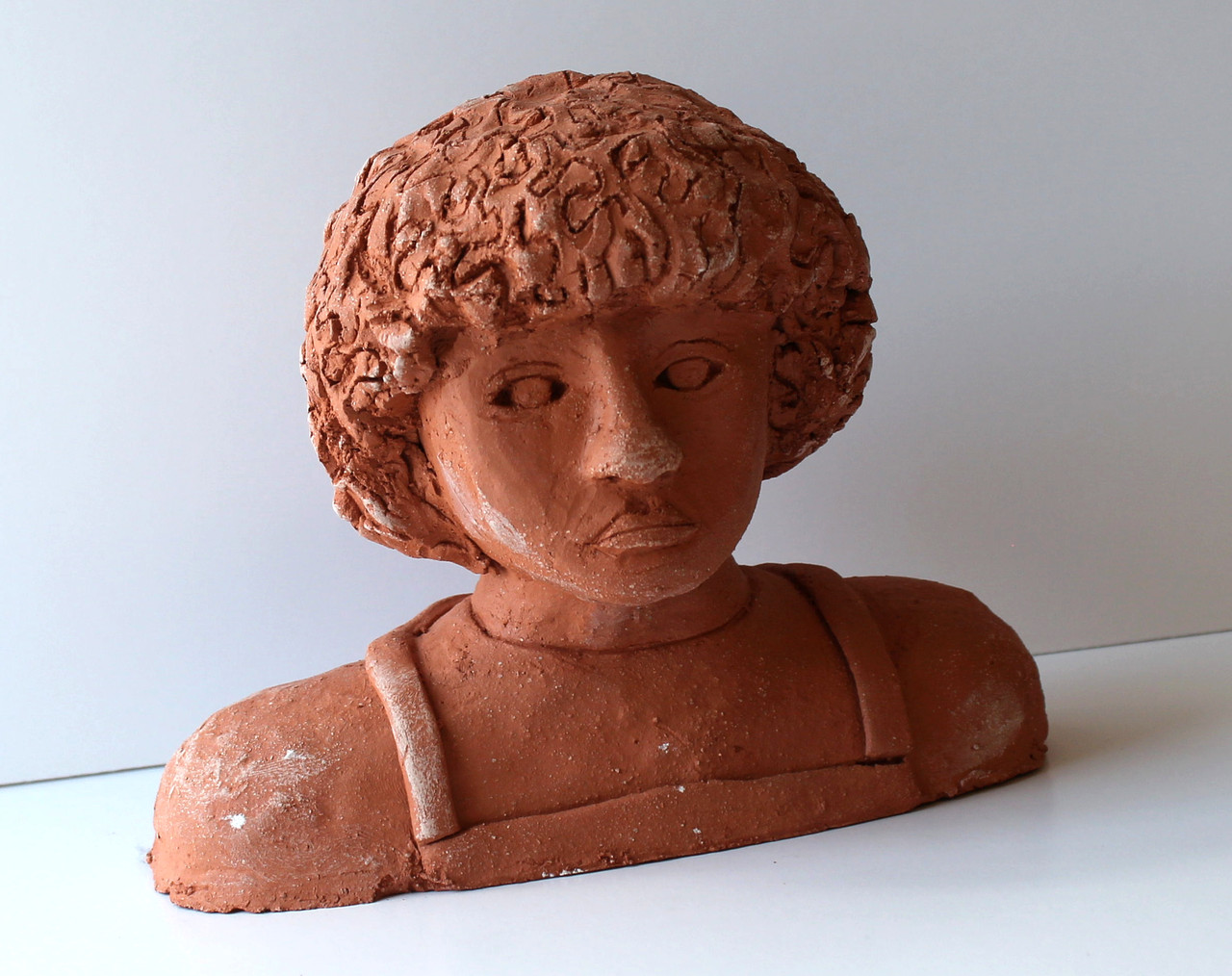 A bust of a student with curly hair.