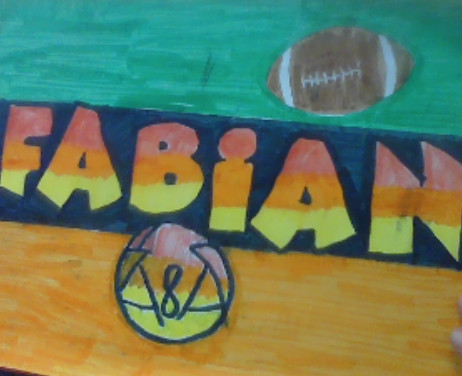 Pink, blue, orange, and yellow drawing with the name "Fabian" in the center and a football above.