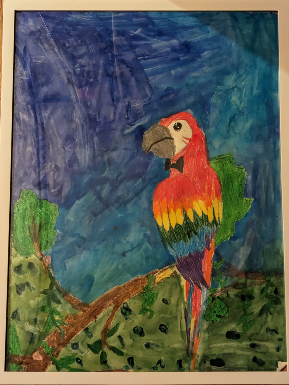 A rainbow mackaw sits on a branch overlooking a blue sky and green background below.