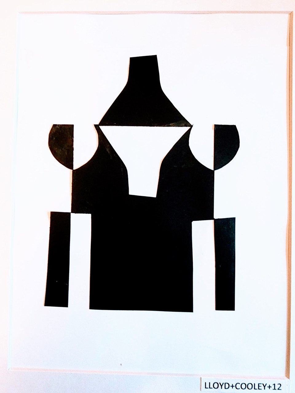 Black construction paper is cut out into an abstract shape and placed over white paper in the Japanese style of Notan.