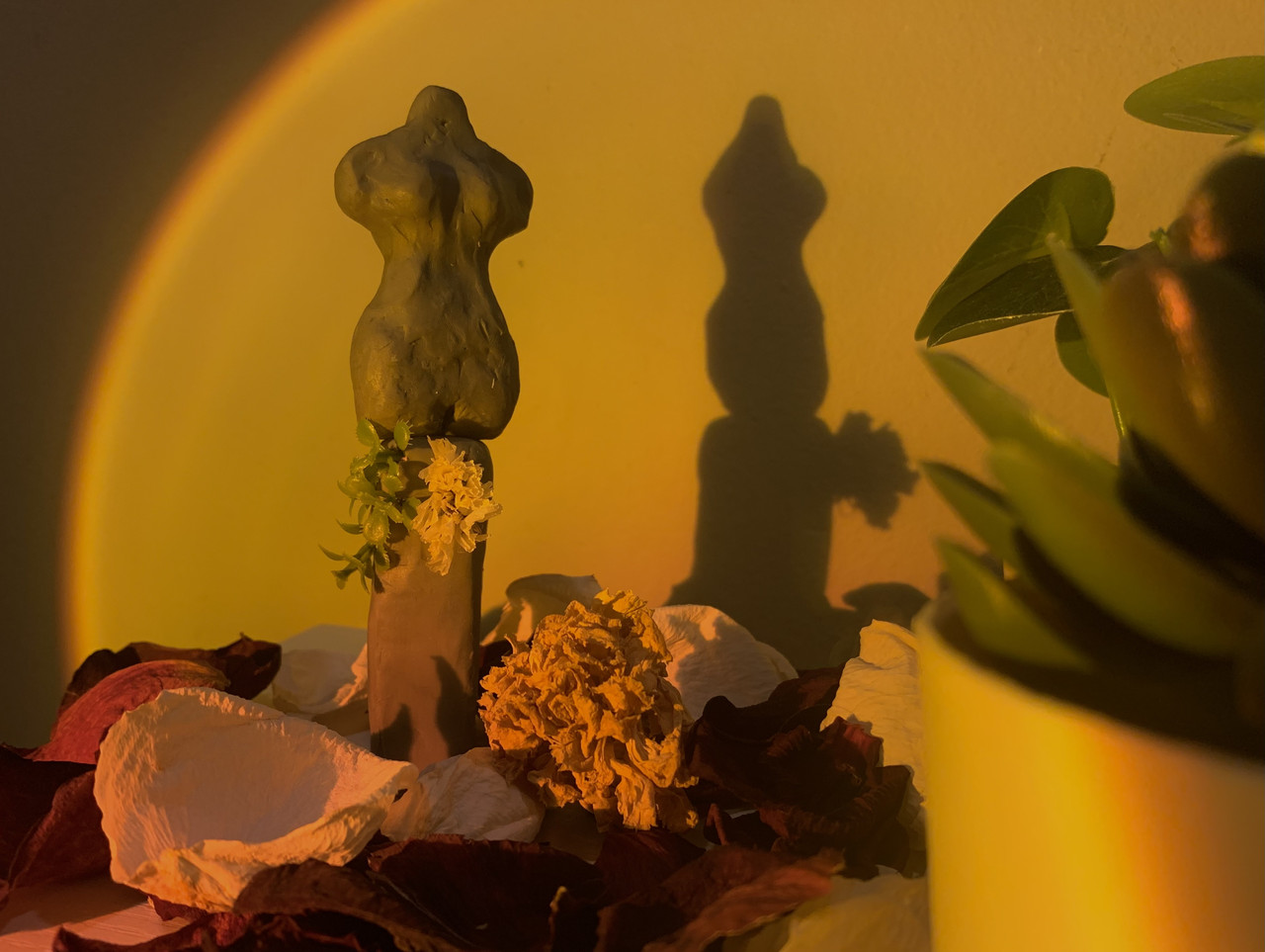 A three dimensional piece of a bust with plants around it.