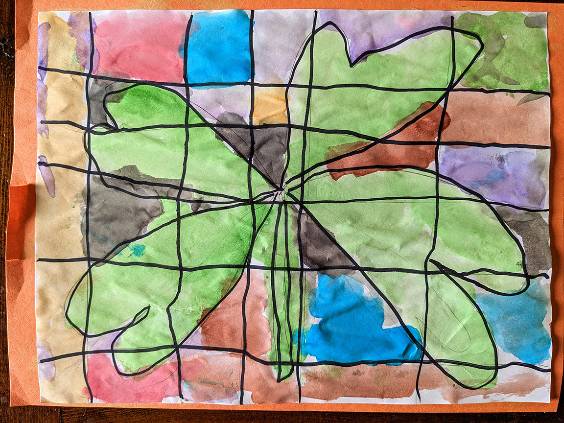 Page is split into squares through black lines that make rows and columns. There is a green clover painted in the middle of the page and other colors surround it.