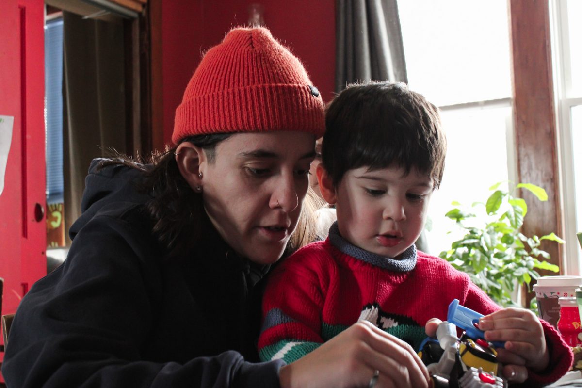A man in an orange hat is with a small child.