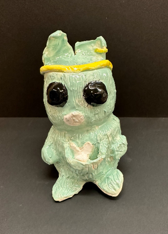 Ceramic green kangaroo with a baby in its pouch. The kangaroo is wearing a yellow sweat band.