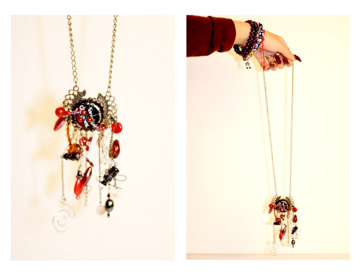 A necklace created by adding red and black elements to a bottle cap.
