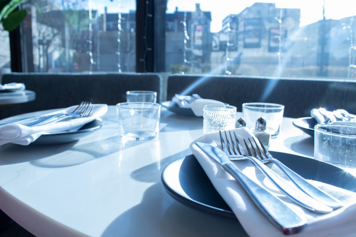 photograph of a set table with cutlery and a window view in the background