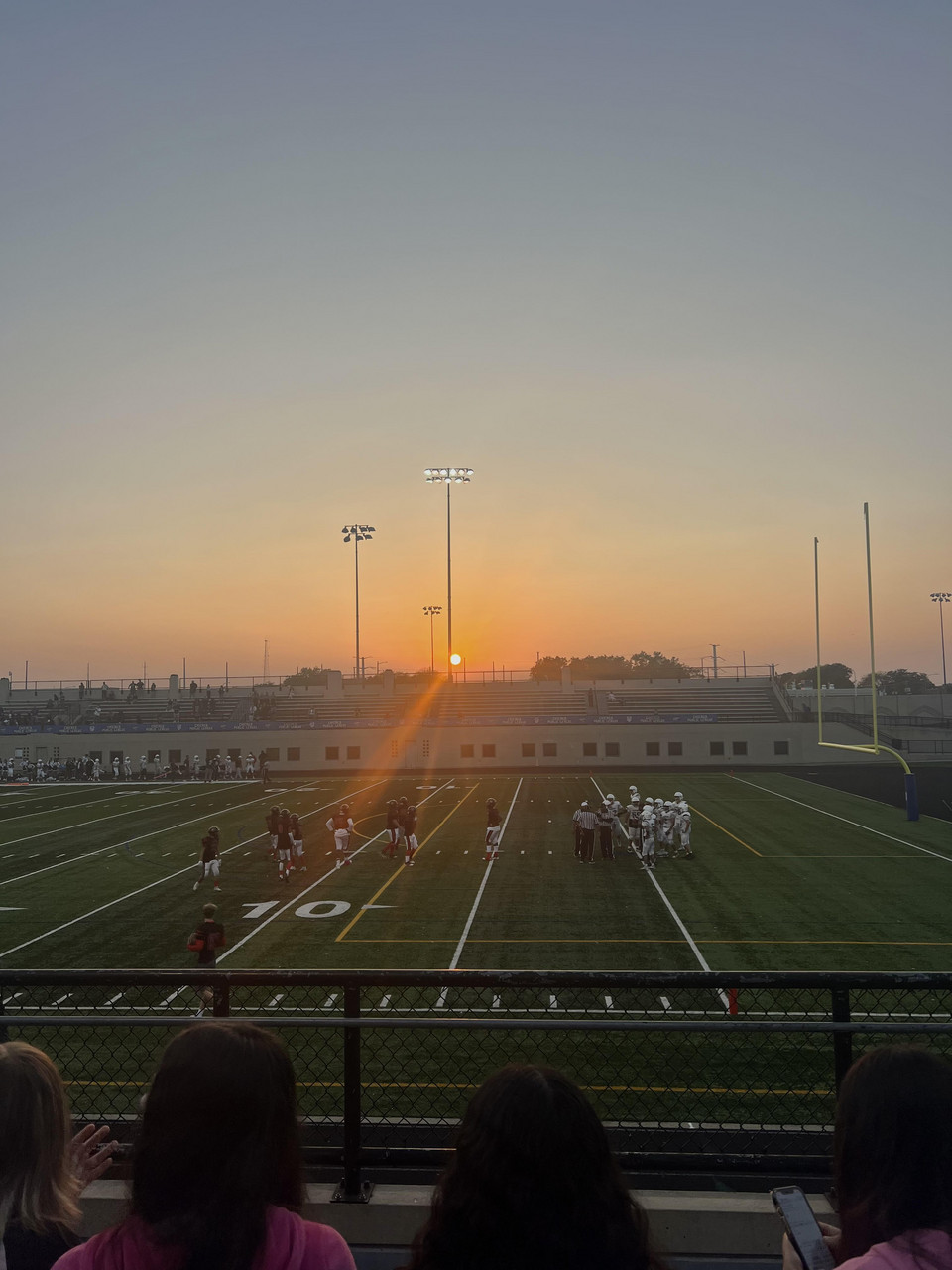 Photograph of a sunset over a football game