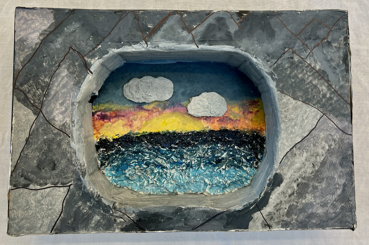 Water with sunset and clouds within an oval.