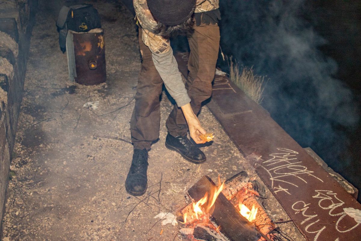 Person feeding a small campfire