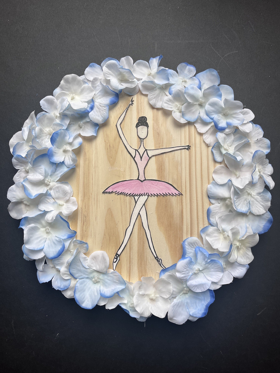 Wooden board with dancer and flowers around her.