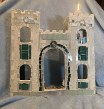 Clay doll house with windows and a candle.
