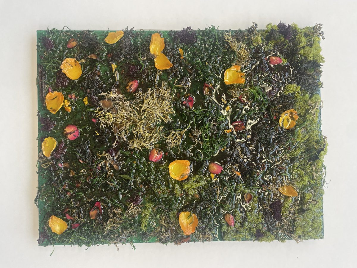 Green strants come out of the surface, ornamented with yellow pieces and smaller pink flecks.