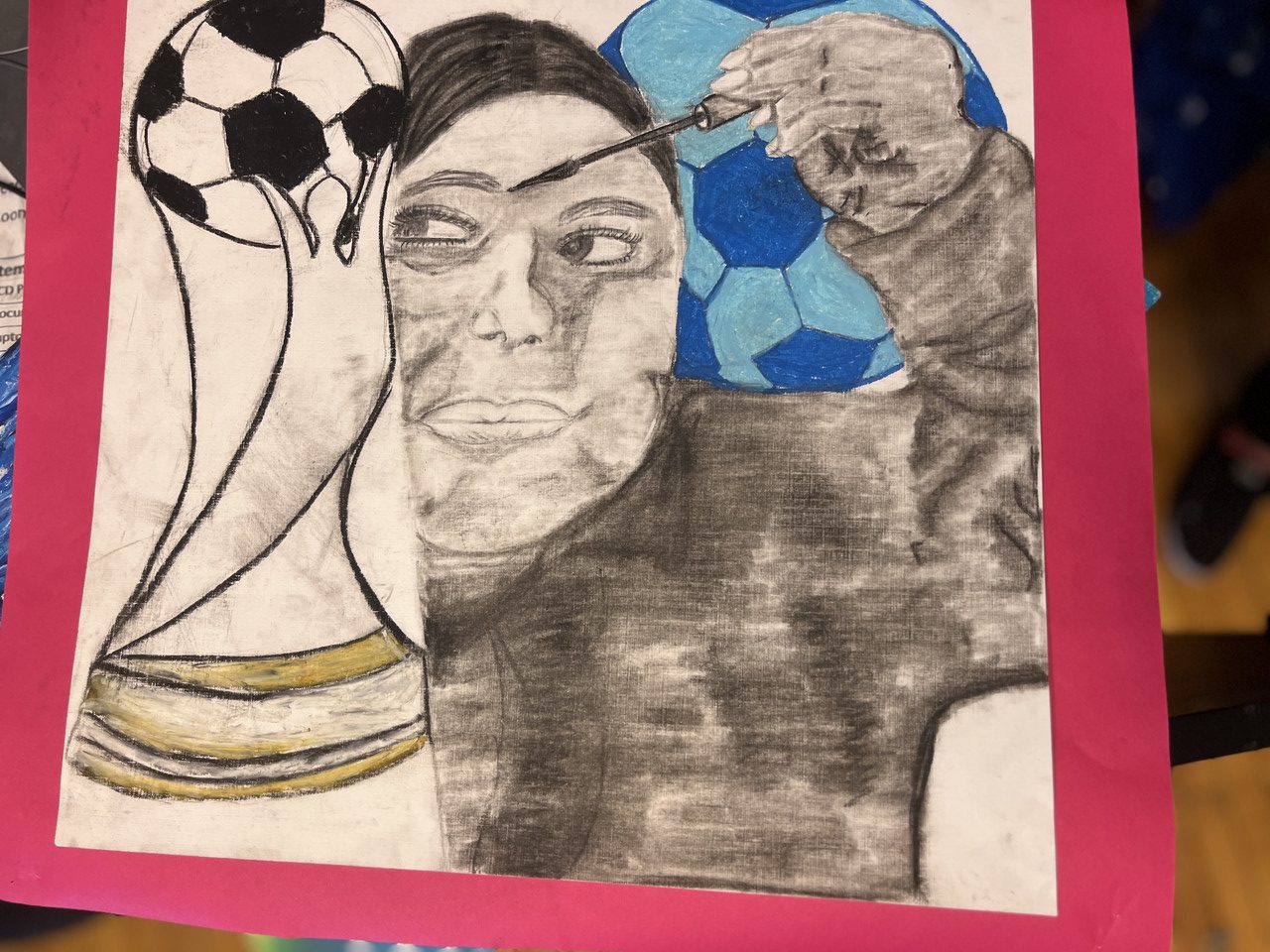 Girl putting on mascara whilst a soccer trophy is on the side of her