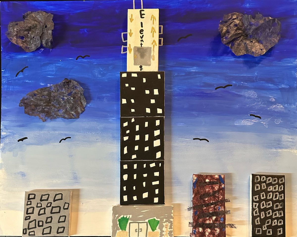Skyline made by layering paper coming out of the page. 4 buildings and sky with clouds.