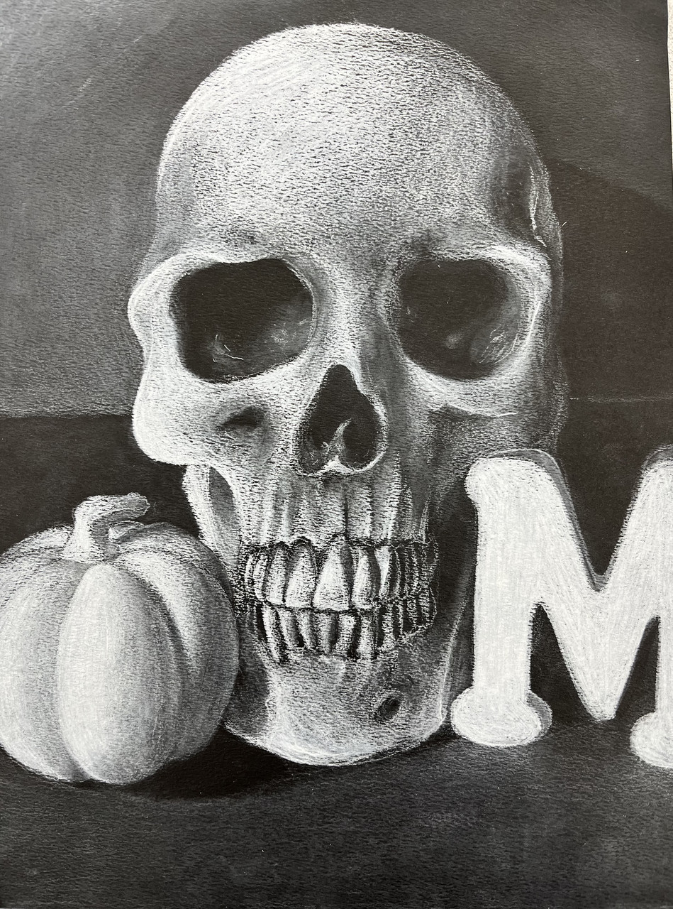 Black and white drawing of a pumpkin, a skull, and a wooden M on a table.