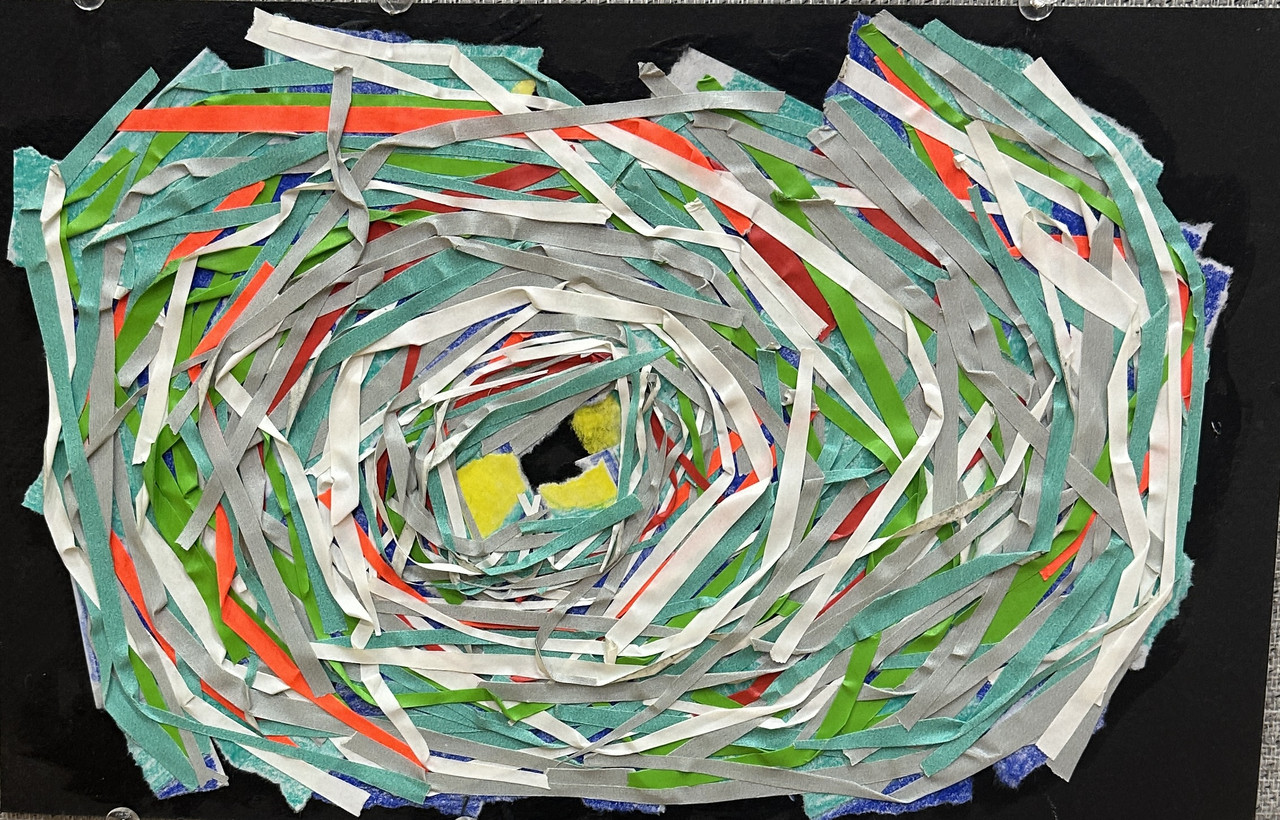 Assortment of different colored tape forming a loose circle that increasingly focuses on the center like a hurricane