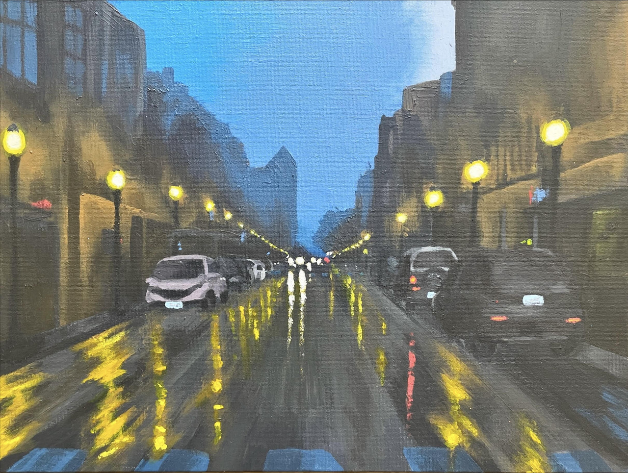 One point of perspective of a street from the point of view as a driver. The sky is a dark blue and the streetlights are illuminating a wet street