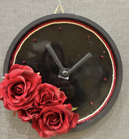 Black clock adorned with red roses