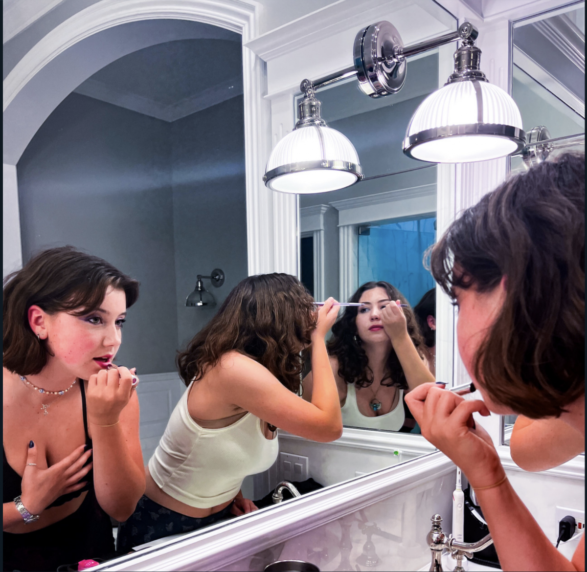 Three individuals in a mirror with reflected