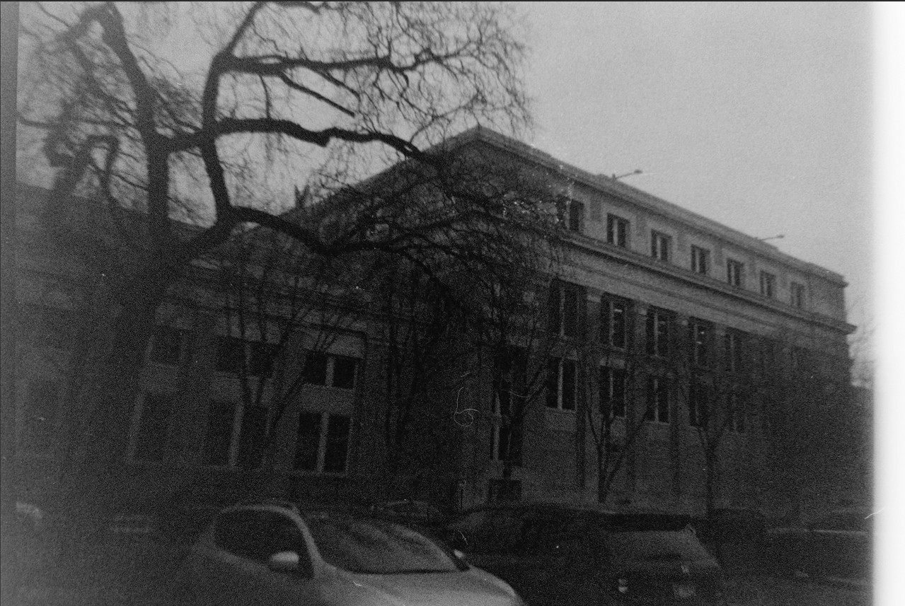 Black and white photo of peering up at a school