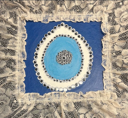mixed media piece with lace, blue, and plastic