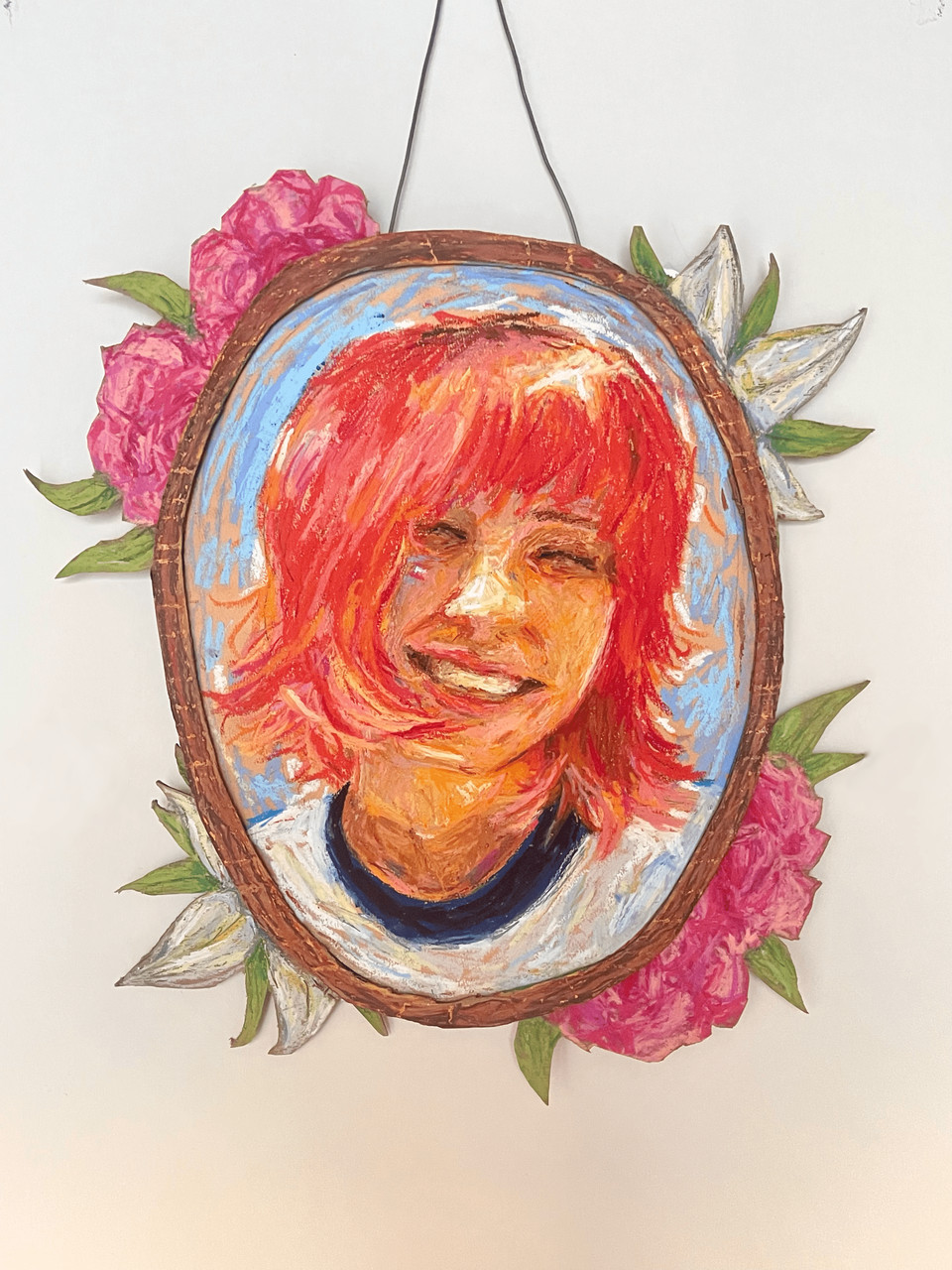 Mixed media art of framed portrait of red and orange toned person surrounded by flowers