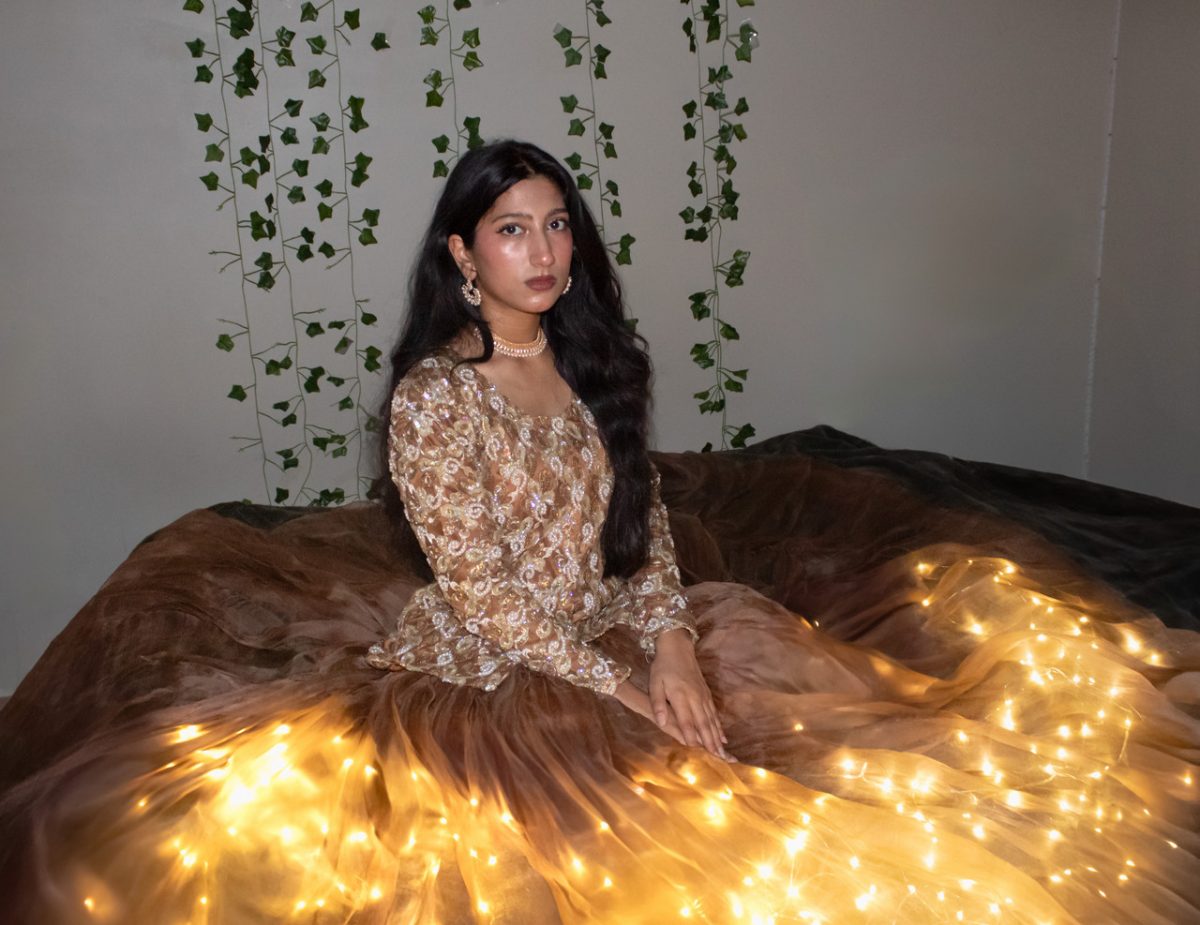 photograph of woman in lace top and large brown skirt with lights shining from underneath