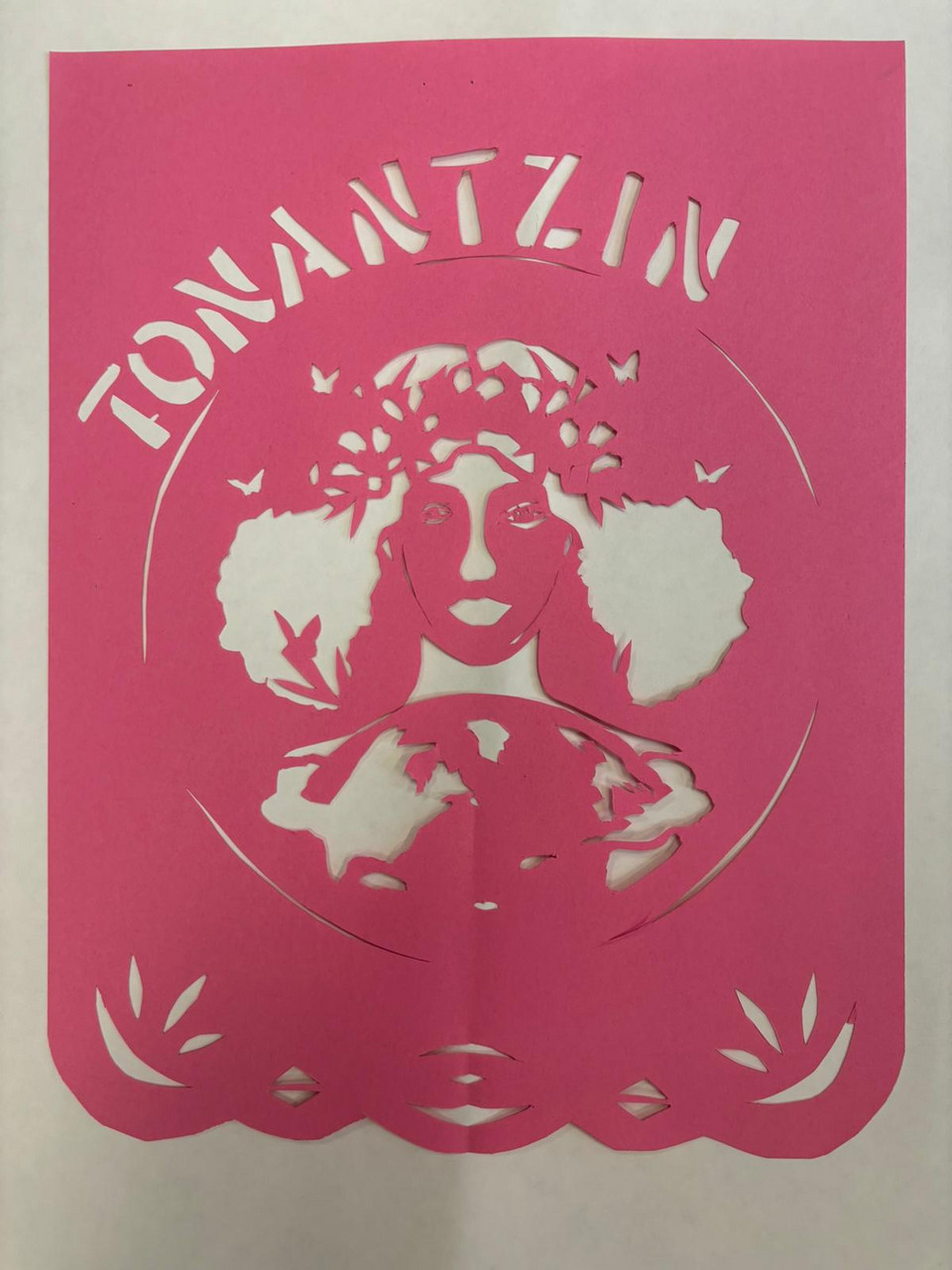 pink paper cutout of womans face with words Tonantzin at top
