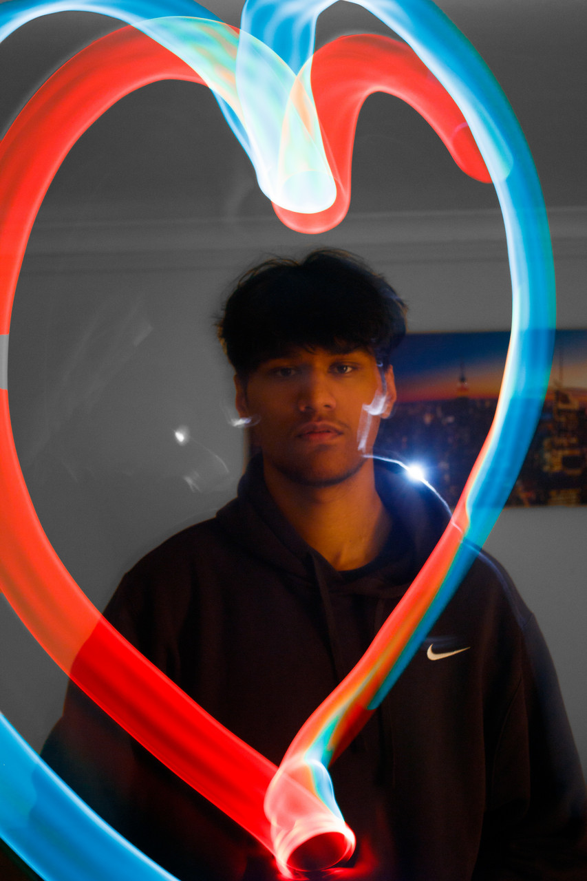 Digital photograph of man in mirror with red and blue glowing hearts across the image