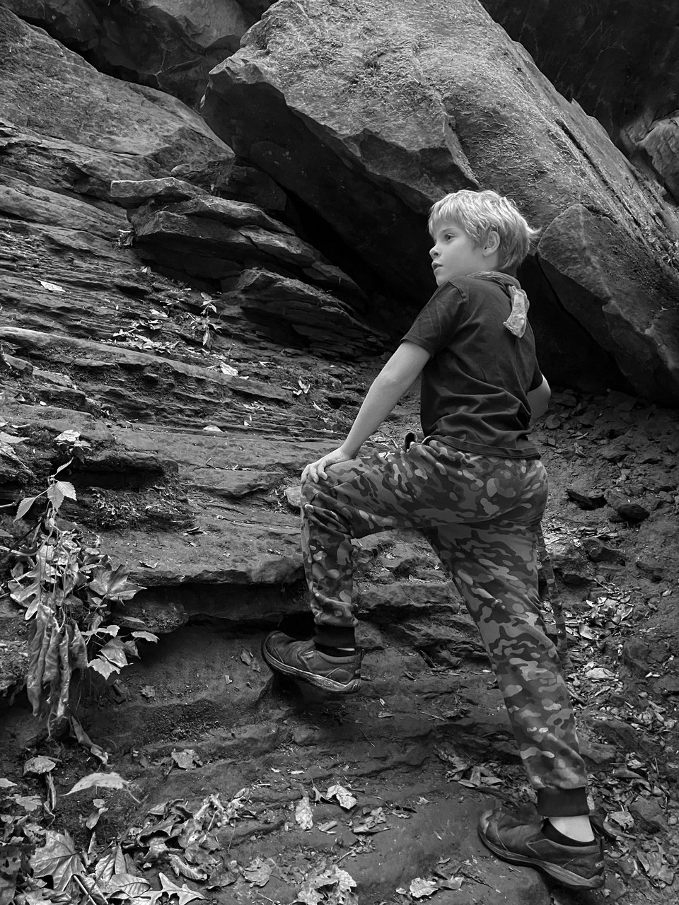 black and white photograph of preson standing on rocks