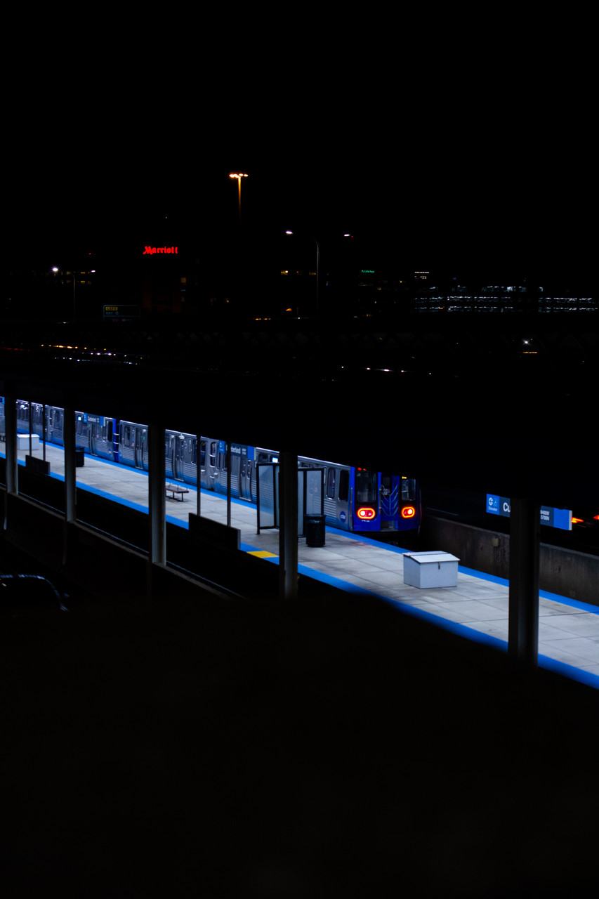 dark photograph with lit up cta blue line train in center