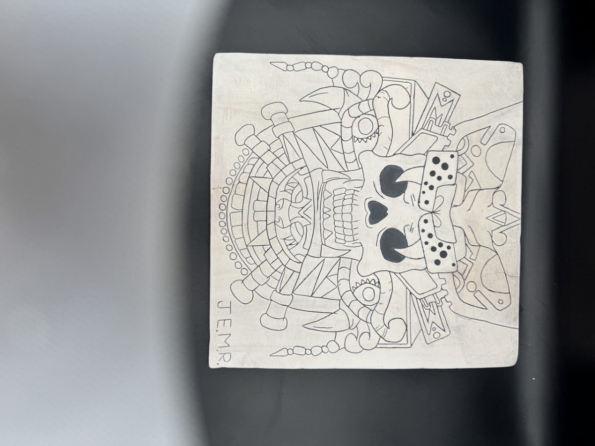 white tile with black image of skull with adornments
