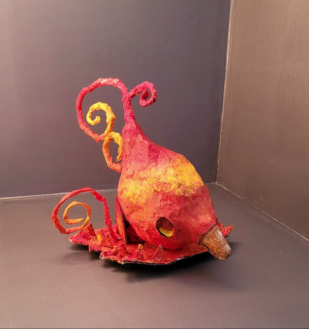 photograph of red and yellow bird sculpture