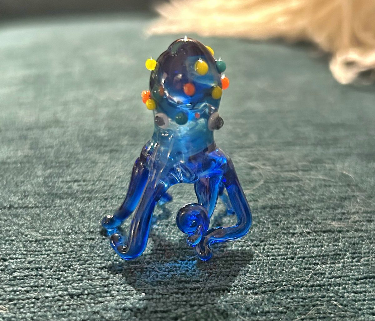 Photograph of blue glass sculpture of octopus with orange and yellow spots
