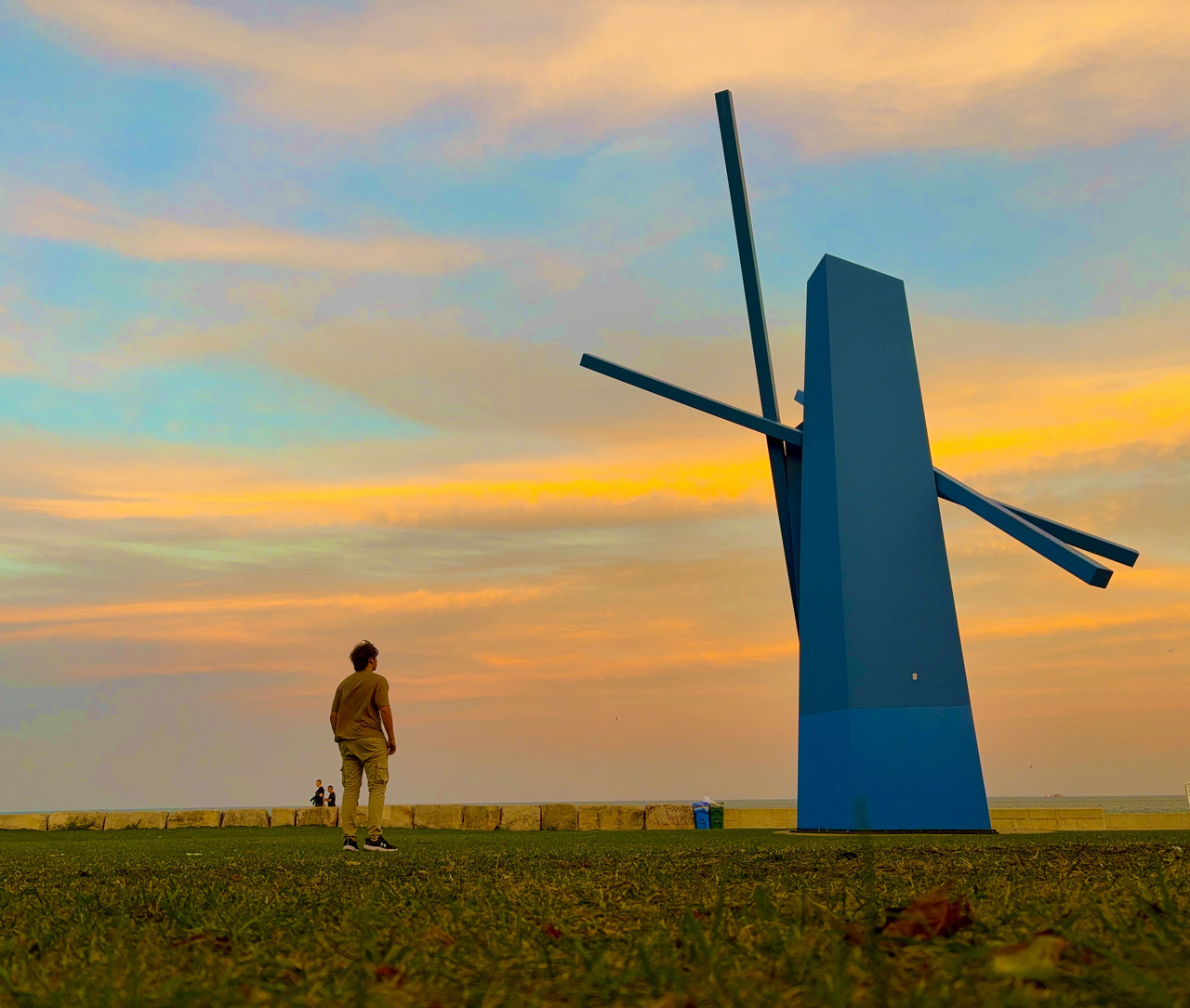 digital photograph of blue orange and yellow sunset with person and lighthouse in the foreground