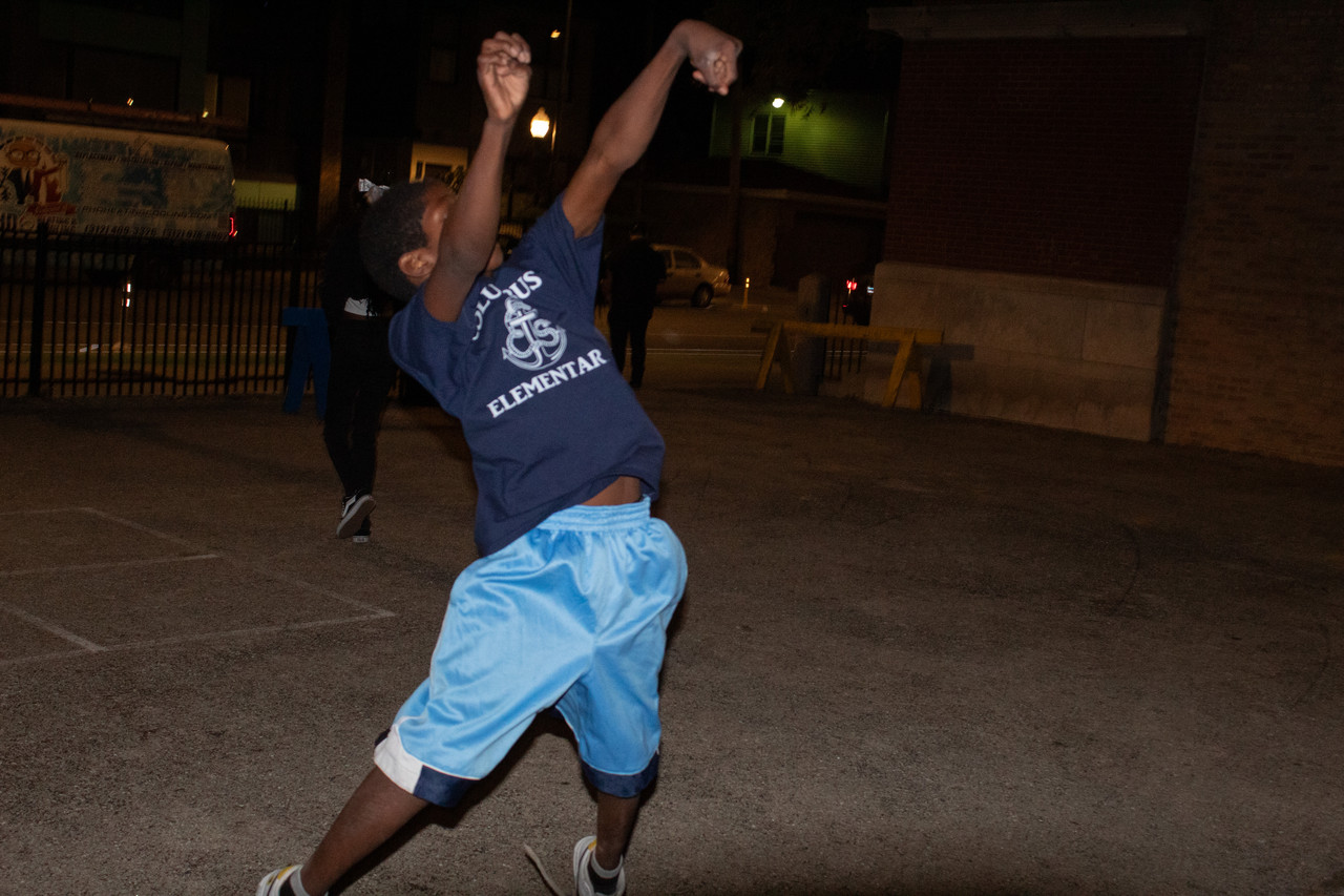 photograph of person shooting a basket wearing blue shirt and shorts
