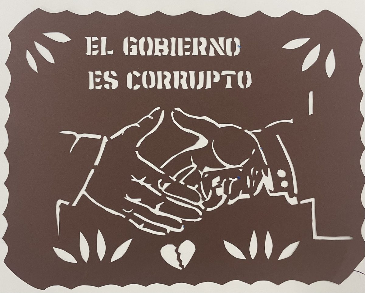 Brown papercut with words el Gobierno es Corrupto, and two shaking hands cut out