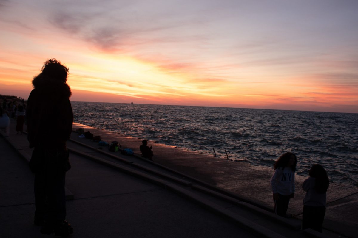 Multicolored sunrise with back of people in foreground